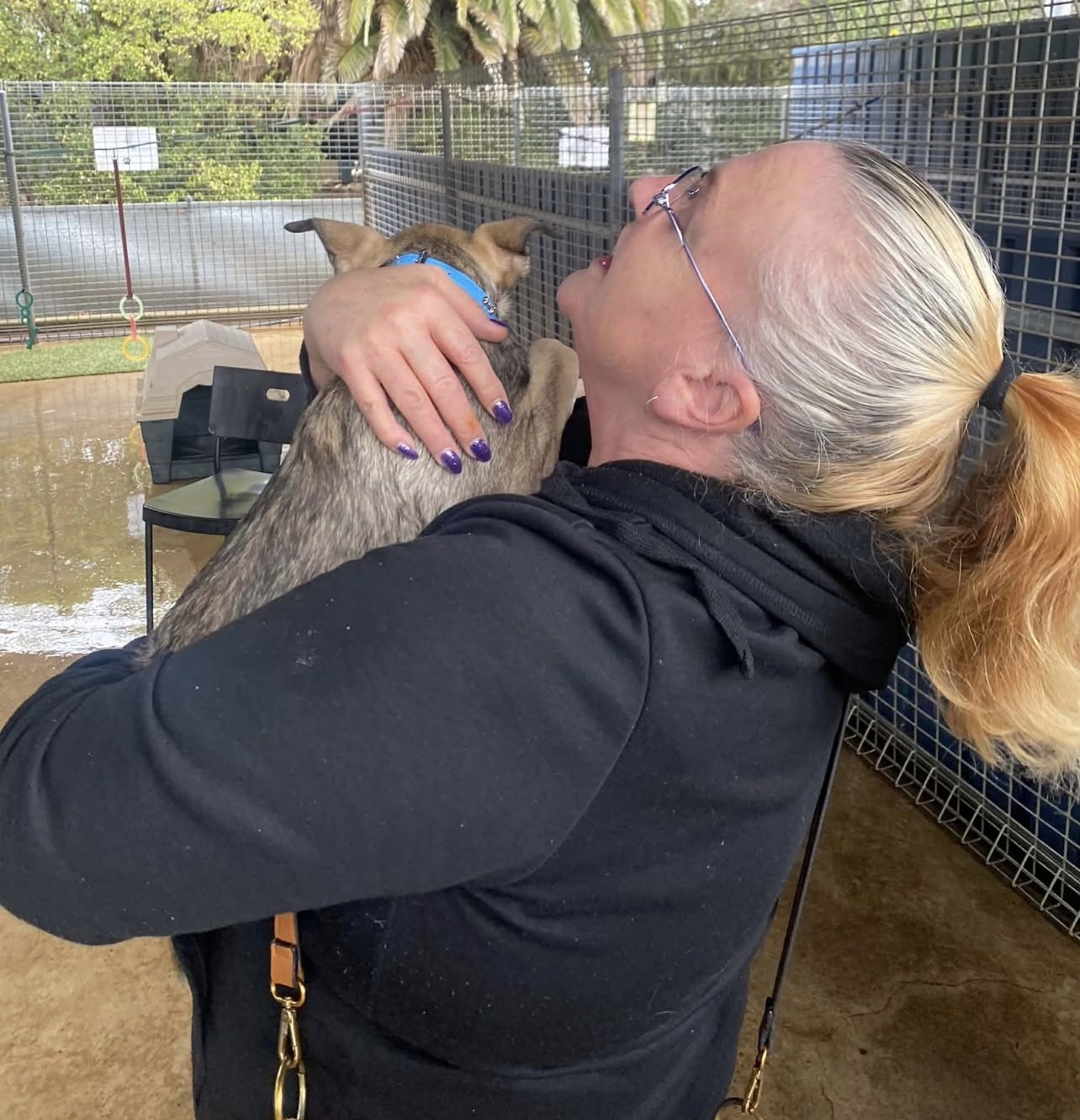 A support worker and participant sharing a warm moment outdoors during a community outing