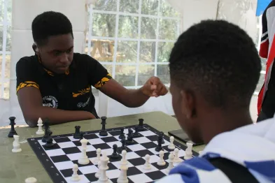 Two young people focused together over a game of chess, building strategy and confidence