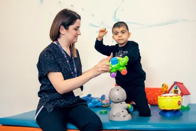 A support worker playing alongside a child, building trust through everyday connection
