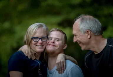 A family embracing warmly outdoors, sharing a moment of joy and connection